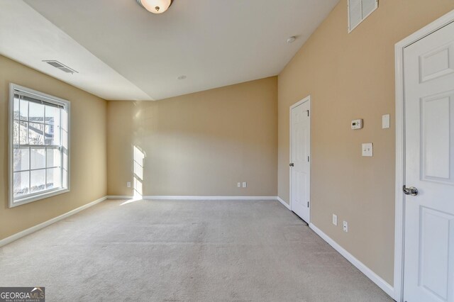 carpeted spare room with baseboards and visible vents