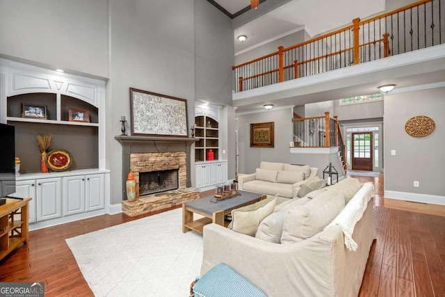 1521 Waterside Ct, Jefferson, GA 30549 - living area featuring a towering ceiling, baseboards, ornamental molding, built in features, and wood finished floors
