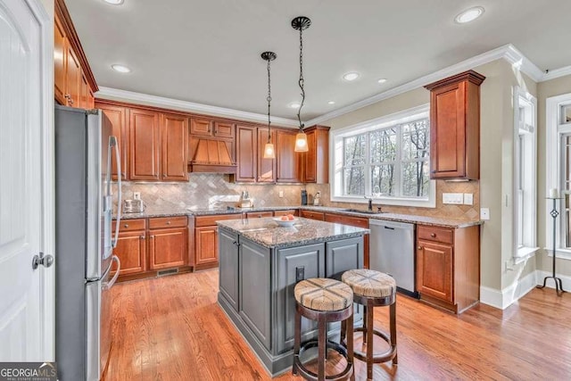 1521 Waterside Ct, Jefferson, GA 30549 - kitchen with appliances with stainless steel finishes, premium range hood, light wood-type flooring, ornamental molding, and brown cabinets