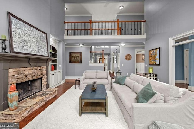 1521 Waterside Ct, Jefferson, GA 30549 - living room with a high ceiling, ornamental molding, baseboards, a stone fireplace, and wood finished floors