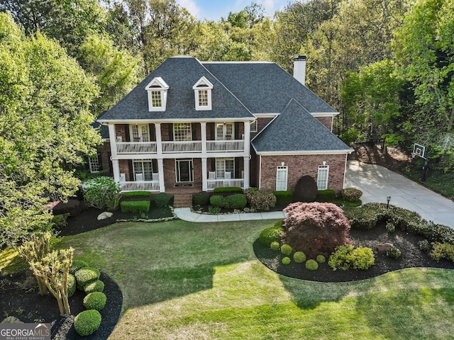 150 Inwood Ter, Roswell, GA 30075 - neoclassical home featuring covered porch, a front lawn, brick siding, a chimney, and a shingled roof