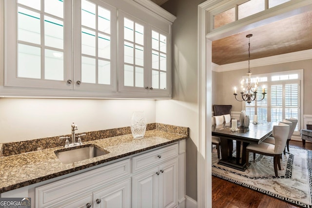150 Inwood Ter, Roswell, GA 30075 - interior space featuring indoor wet bar, crown molding, dark wood-type flooring, pendant lighting, and a sink