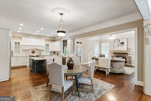 150 Inwood Ter, Roswell, GA 30075 - dining space with baseboards, dark wood-style flooring, ornamental molding, a stone fireplace, and ceiling fan