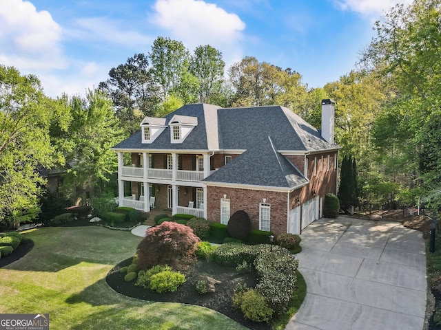 150 Inwood Ter, Roswell, GA 30075 - neoclassical home featuring a porch, a garage, brick siding, a front lawn, and driveway