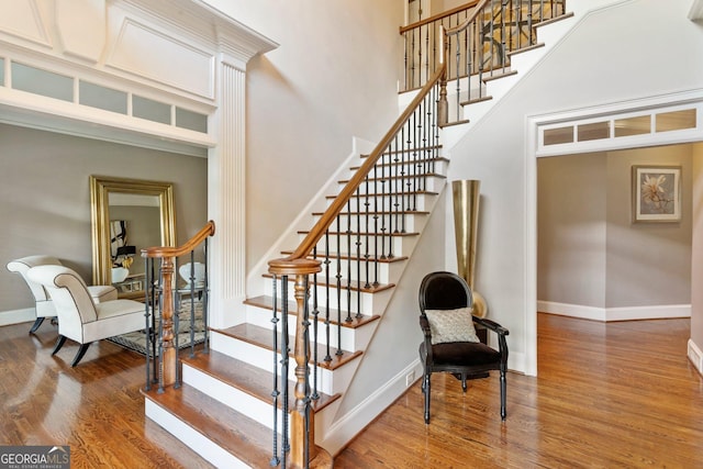 150 Inwood Ter, Roswell, GA 30075 - stairway featuring a high ceiling, baseboards, and wood finished floors