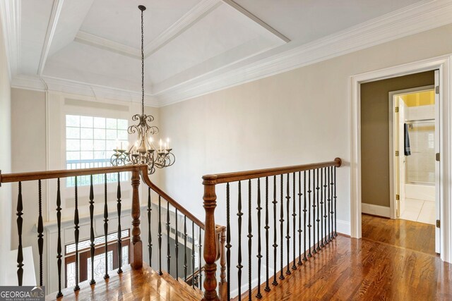 150 Inwood Ter, Roswell, GA 30075 - stairway featuring crown molding, an inviting chandelier, wood finished floors, a raised ceiling, and baseboards