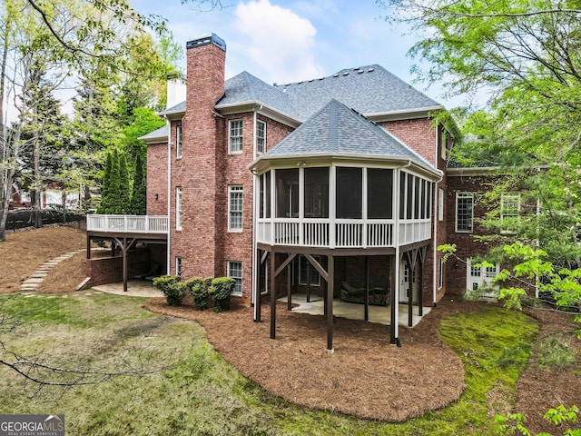 150 Inwood Ter, Roswell, GA 30075 - back of house featuring a sunroom, a patio, roof with shingles, brick siding, and a chimney