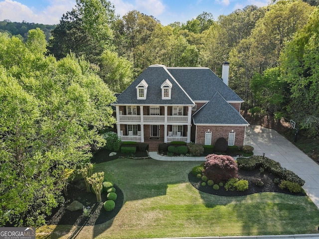 150 Inwood Ter, Roswell, GA 30075 - view of front facade featuring a chimney, a front yard, brick siding, a shingled roof, and covered porch