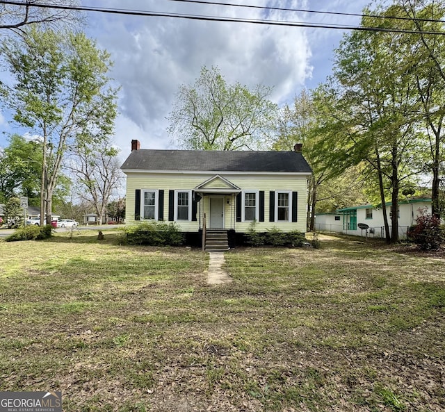 view of front of house with a front yard and a chimney