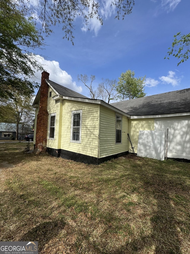 back of property featuring a lawn and a chimney