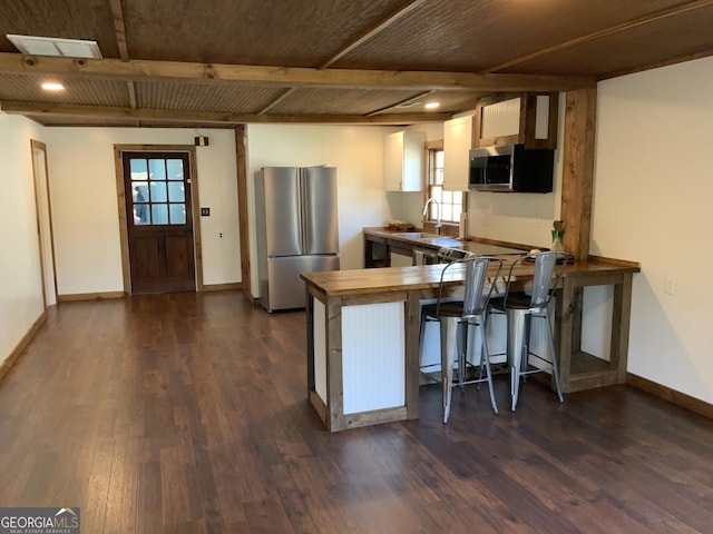 2790 Old Farmington Rd, Watkinsville, GA 30677 - kitchen featuring stainless steel appliances, dark wood-style floors, a peninsula, beam ceiling, and a kitchen bar