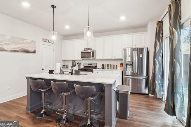 137 Park Chase Ln, Dallas, GA 30132 - kitchen with white cabinetry, light countertops, dark wood-style flooring, stainless steel appliances, and a kitchen island with sink