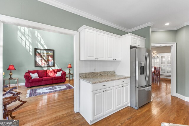 404 Golden Delicious Rd, Clarkesville, GA 30523 - kitchen with ornamental molding, light wood-style flooring, white cabinetry, and stainless steel fridge