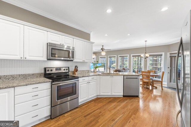 404 Golden Delicious Rd, Clarkesville, GA 30523 - kitchen with ornamental molding, white cabinetry, stainless steel appliances, and light wood-style flooring