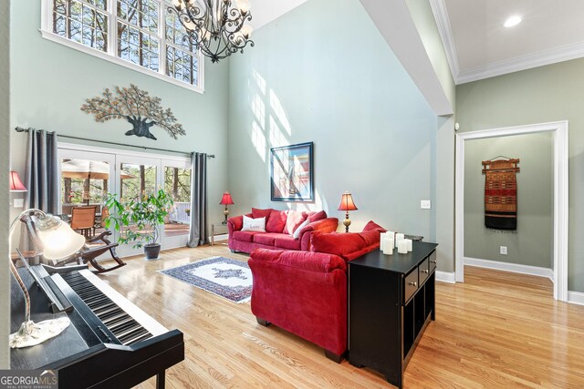 404 Golden Delicious Rd, Clarkesville, GA 30523 - living room with a high ceiling, an inviting chandelier, ornamental molding, baseboards, and light wood-style flooring