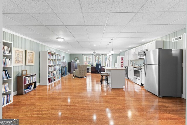 404 Golden Delicious Rd, Clarkesville, GA 30523 - kitchen with open floor plan, a breakfast bar, stainless steel appliances, white cabinetry, and visible vents