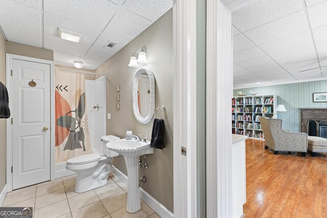 404 Golden Delicious Rd, Clarkesville, GA 30523 - full bathroom featuring tile patterned floors, a paneled ceiling, a shower with curtain, toilet, and baseboards