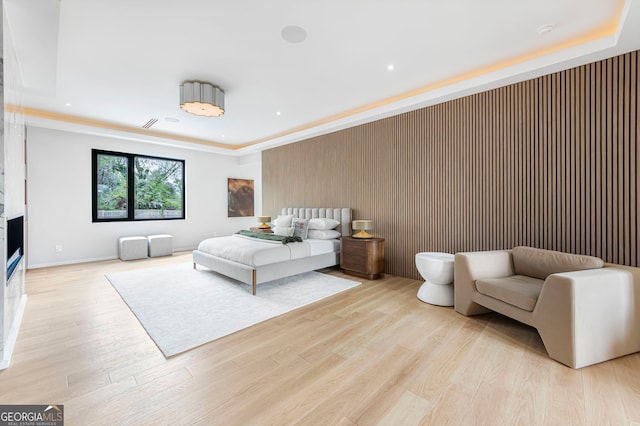 bedroom featuring a fireplace, light wood finished floors, and recessed lighting