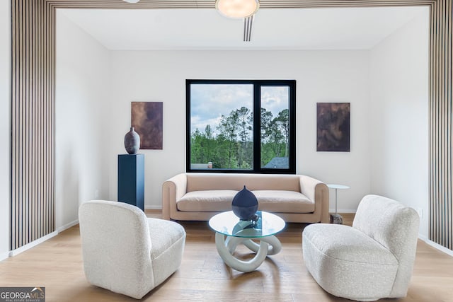 living area with baseboards and wood finished floors