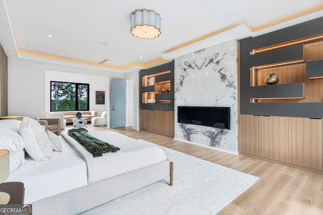 bedroom with a fireplace, wood finished floors, and visible vents