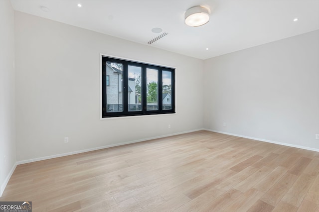 empty room with recessed lighting, visible vents, light wood finished floors, and baseboards