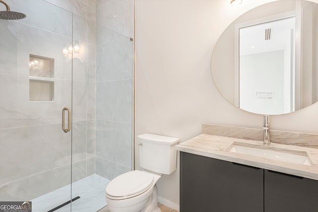 full bathroom with vanity, a shower stall, and toilet