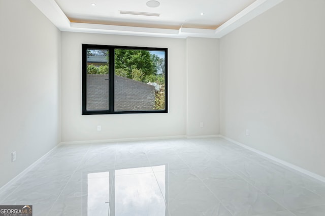 unfurnished room with visible vents, baseboards, and a tray ceiling