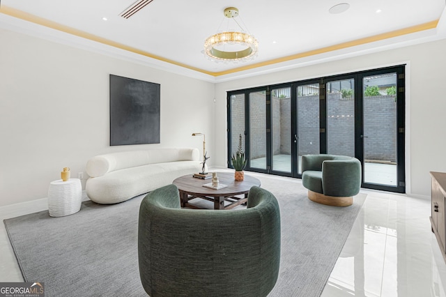 living area with a chandelier, visible vents, and a raised ceiling