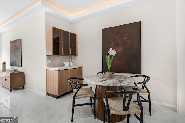 dining area featuring marble finish floor and baseboards