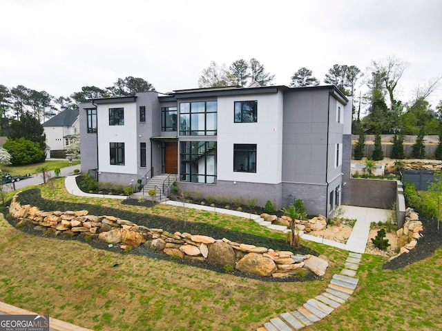 view of front facade with a balcony, a front yard, and a garage