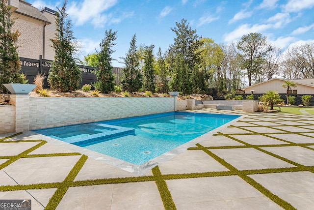view of pool featuring a fenced backyard, a patio area, and a pool with connected hot tub