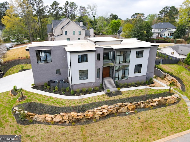contemporary house with fence, a balcony, and stucco siding