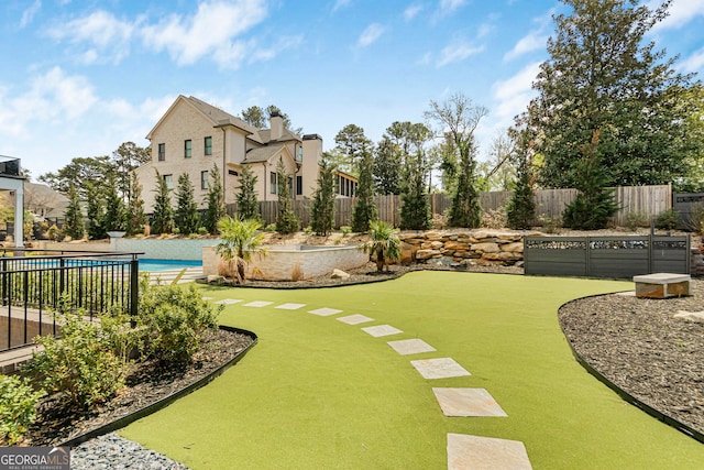 view of yard featuring fence and a fenced in pool