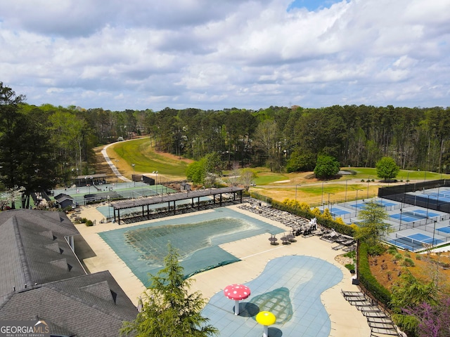 view of swimming pool with a forest view