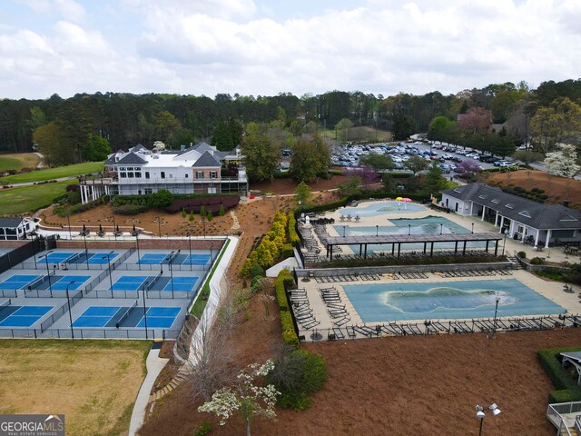 view of swimming pool featuring a tennis court and fence