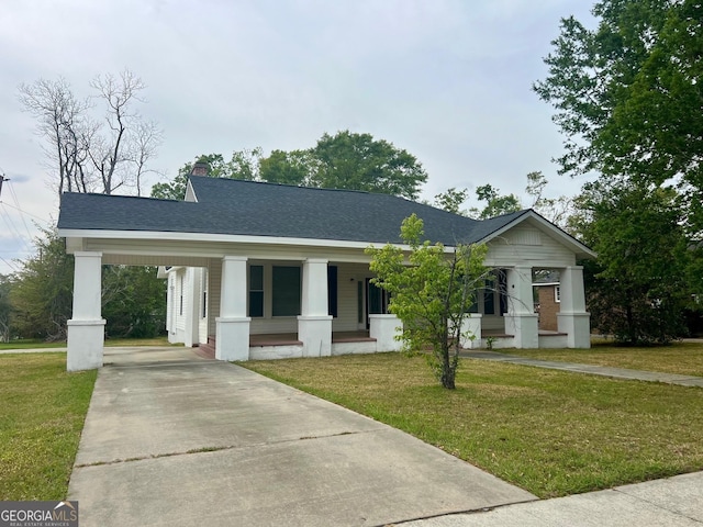 view of front facade featuring a chimney, concrete driveway, an attached carport, a front lawn, and a shingled roof