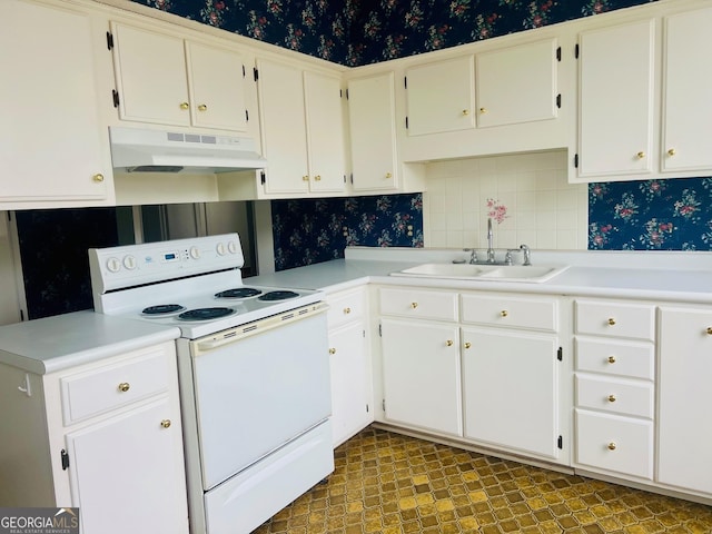 kitchen with light countertops, white cabinets, under cabinet range hood, electric stove, and a sink