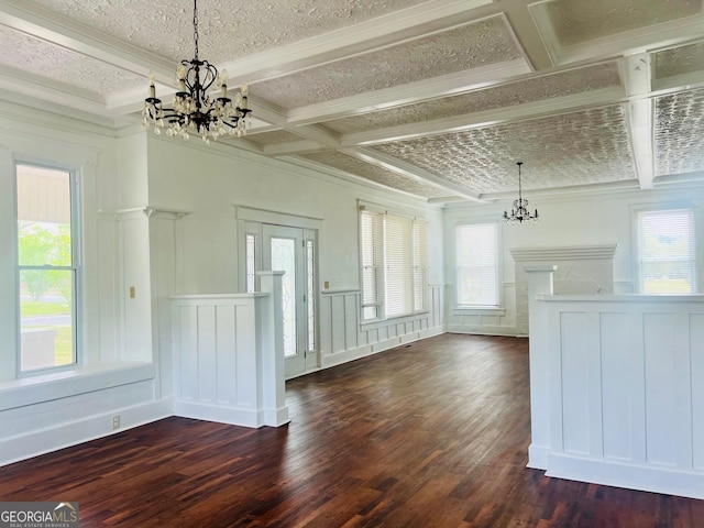 unfurnished living room with dark wood-style flooring, a textured ceiling, beam ceiling, coffered ceiling, and a notable chandelier