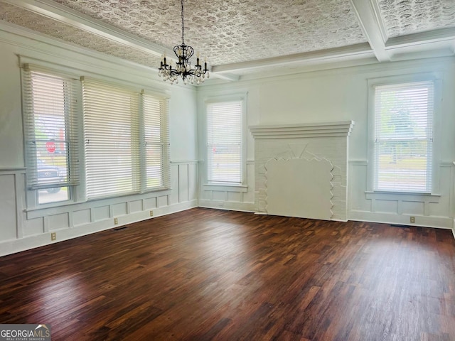 unfurnished living room featuring ornamental molding, a decorative wall, a notable chandelier, and wood finished floors