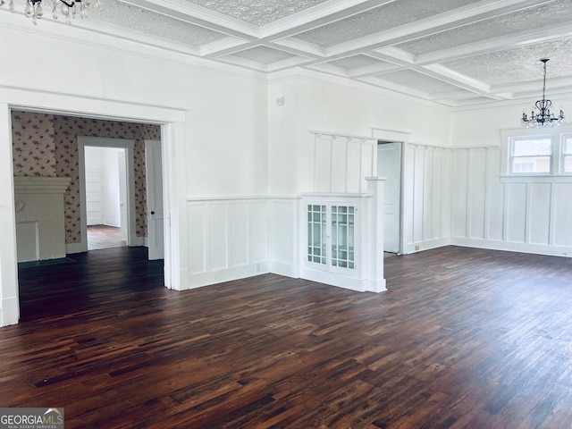 unfurnished living room featuring an inviting chandelier, dark wood-type flooring, and coffered ceiling