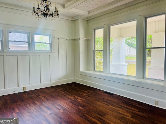 empty room with dark wood-style floors, a decorative wall, visible vents, and plenty of natural light