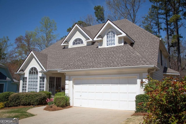 view of front facade with a garage, driveway, and roof with shingles