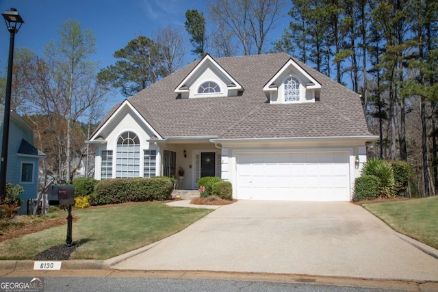 view of front of property featuring driveway, roof with shingles, an attached garage, and a front lawn