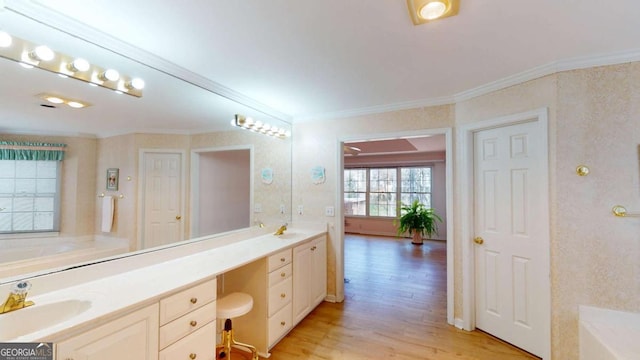 full bathroom with a garden tub, double vanity, a sink, and wood finished floors