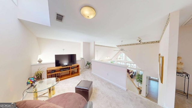 carpeted living area with visible vents, lofted ceiling, and baseboards