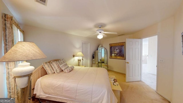 bedroom featuring visible vents, a ceiling fan, and light carpet
