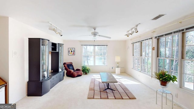 living area featuring track lighting, ceiling fan, carpet floors, and visible vents