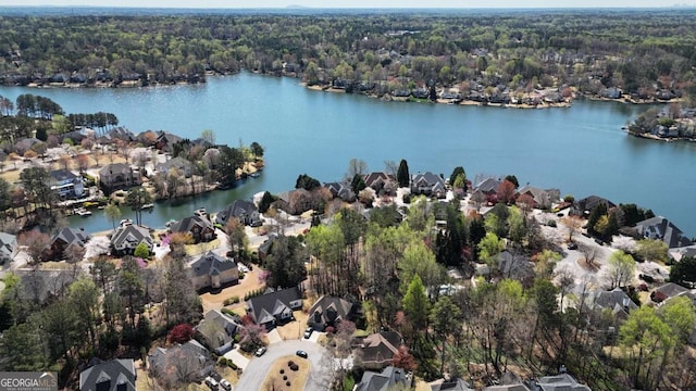 drone / aerial view featuring a water view, a residential view, and a view of trees