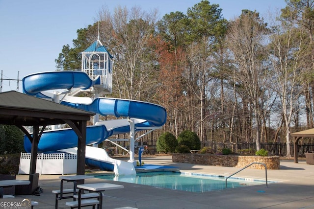 community pool featuring a patio, a gazebo, a water slide, and fence