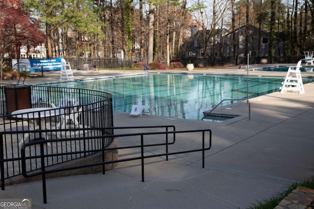 pool featuring fence and a patio area